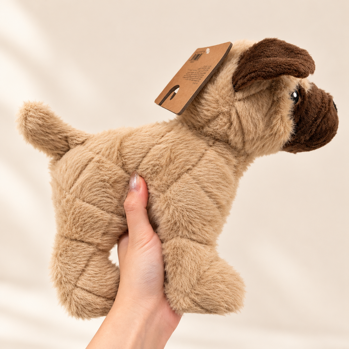 Pugsley plush pug dog toy held in hand